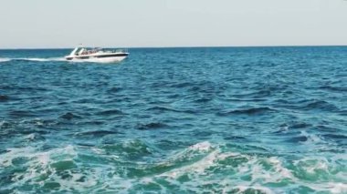 İnsanlarla dolu tekne yazın mavi dalgalarla denize açılacak. Deniz gezisi. Ağır çekim. Deniz Burnu