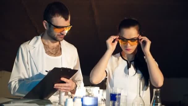 Una Mujer Vestido Gafas Laboratorio Está Examinando Reacción Una Sustancia — Vídeo de stock