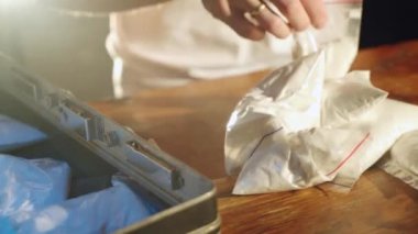 Uyuşturucu satıcısı bavuluna uyuşturucu dolduruyor. Yakın plan. Uyuşturucu bağımlılığı. Kriminal İş