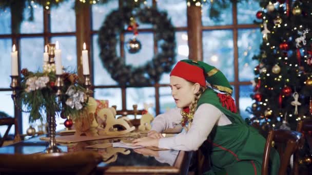 Эльфийская Девушка Проснулась Столом Поздравительными Письмами Подарками Свечами Фоне Новогодней — стоковое видео