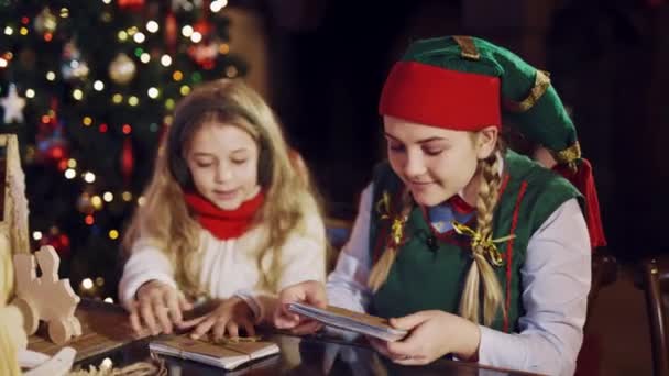 Funny Elf Sitting Table Little Girl Showing How Tie Stack — Stock Video