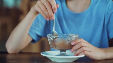 Çocuk bir kafede dondurma yiyor. Dondurmalı çocuk.