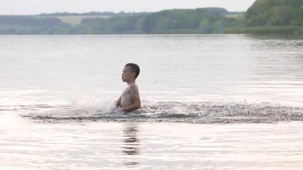 水の中に飛び込む 男の子は水の中で楽しさと水しぶきをしています 夏休みのコンセプト — ストック動画