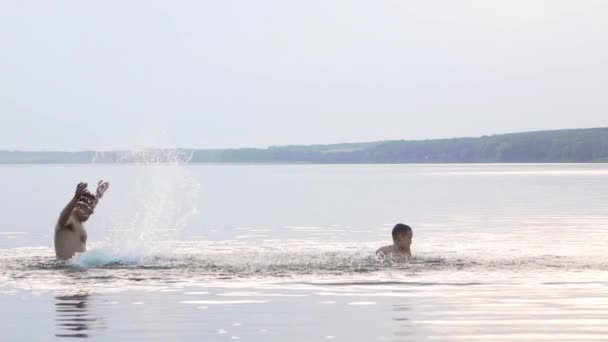 水の中に飛び込む 男と男の子は水の中で楽しさと水しぶきをしています 夏休みのコンセプト — ストック動画