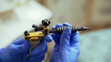 Güzellik ustası, arka planda bulanık bir güzellik stüdyosunda elinde kalıcı makyaj için bir makina tutuyor. Yakın plan.