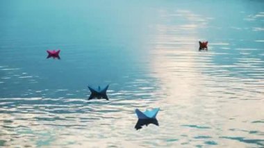 Nehirde yüzen kağıt tekneler. Güzel yaz günbatımı. Origami.