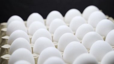 Karton bir kutuda beyaz tavuk yumurtası. Kağıt tepside yumurtalar.