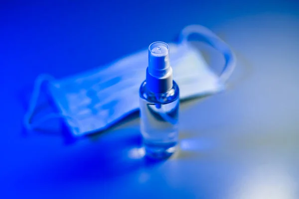 Μάσκα Προσώπου Και Μπουκάλι Απολυμαντικό Χεριών Μπλε Φόντο Σταμάτα Διαδίδεις — Φωτογραφία Αρχείου