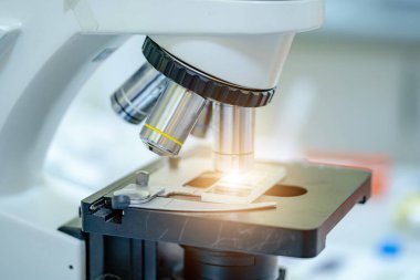 Mikroskobun yatay görüntüsü. Araştırma için hazırız. Bakteriler ve virüsler tanımlanıyor. Kapat.