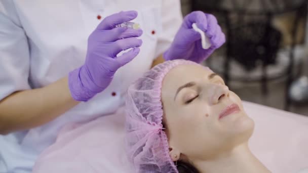 一个漂亮的女人正在进行面部恢复的过程 美容师对前额区域进行间歇性治疗 注射美容品 — 图库视频影像