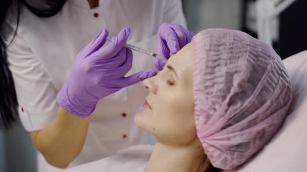 一位经验丰富的美容师在眉毛区域为女性制造肉毒杆菌毒素 面部皮肤年轻化 化妆品学 侧视图 — 图库视频影像