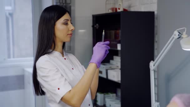 Cosmétologue Mignon Aux Cheveux Longs Vérifie Une Seringue Avant Procédure — Video