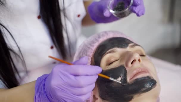 Ein Arzt Kosmetiker Trägt Eine Schwarze Maske Mit Einem Pinsel — Stockvideo