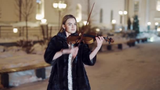 Mladá Dívka Černém Plášti Hraje Zimě Housle Pozadí Budov Večerních — Stock video