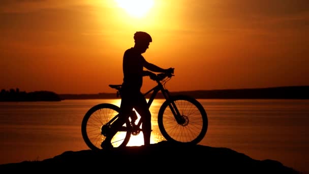 バイカーは丘の上の自転車に乗る 夕暮れ時に岩の歩道にマウンテンバイクとサイクリスト — ストック動画