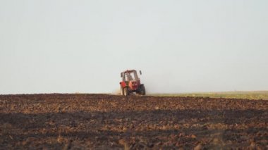 Tarlada çalışan çiftçi. Traktördeki çiftçi tohum ekiciyle toprağı hazırlıyor.