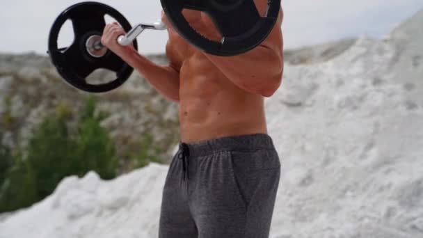 Człowiek Ćwiczący Naturze Atletyczny Fitness Człowiek Pompuje Mięśnie Sztangą Zewnątrz — Wideo stockowe