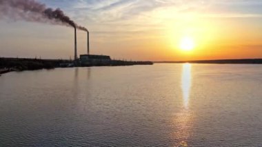 Yansıma nehri olan günbatımı bulutları. Gün batımında nehir kıyısında manzara