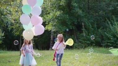 Kızlar parkta eğleniyor. Parkta büyük renkli balonları olan güzel kızlar.