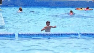 Çocuk bilardoda oynuyor. Mutlu çocuk yüzme havuzunda oynuyor