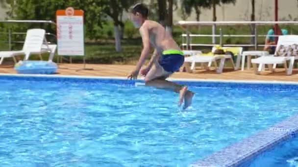 少年はプールに飛び込む 幸せな男の子ジャンプでザ プール — ストック動画