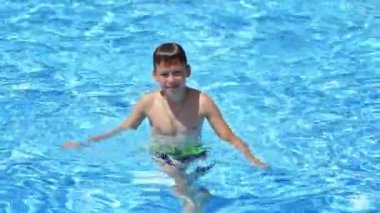 Havuzdaki çocuk. Yüzme havuzunda mutlu çocuklar yaz tatilinde eğleniyorlar.