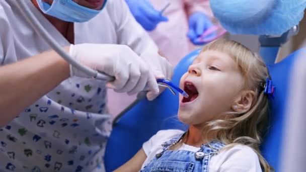 可爱的女孩在牙科诊所 在诊所和小女孩一起工作的专业牙医 — 图库视频影像