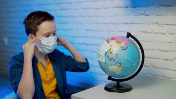 Хлопчик Дивиться Глобус Дізнавшись Про Поширення Вірусу Всьому Світу — стокове відео