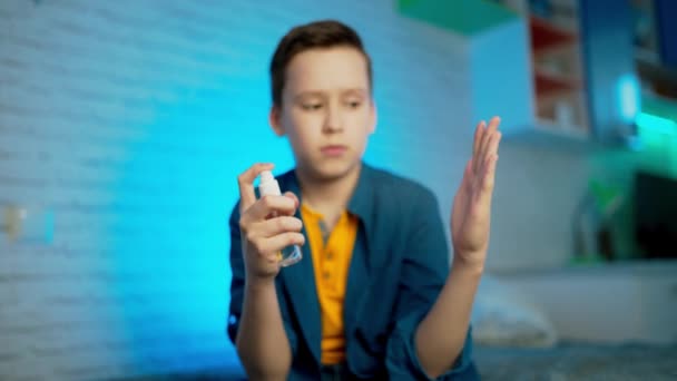 少年は 細菌やウイルスの拡散を防ぐためにアルコールスプレーや抗菌スプレーを適用します 個人衛生の概念 — ストック動画