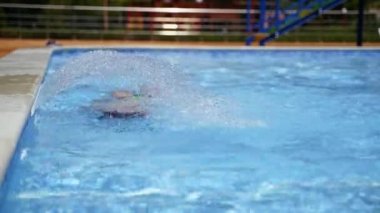 Havuzda yüzen bir çocuk. Yüzme havuzunda yüzen ve şnorkelle yüzen sevimli küçük çocuk.