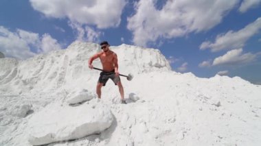 Adam dışarıda egzersiz yaparken çekiç darbesi yapıyor. Spor fitness antrenmanı sırasında çekiçle taşa vuran adam.