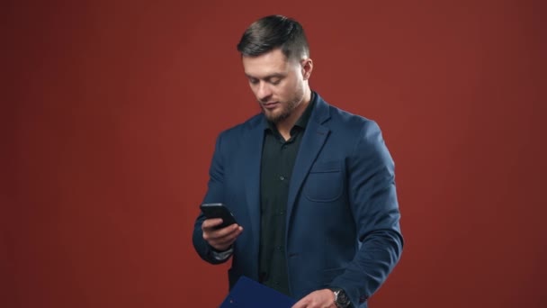 携帯電話を持ってる男 スマートフォンのテキストメッセージを持つビジネスマン — ストック動画
