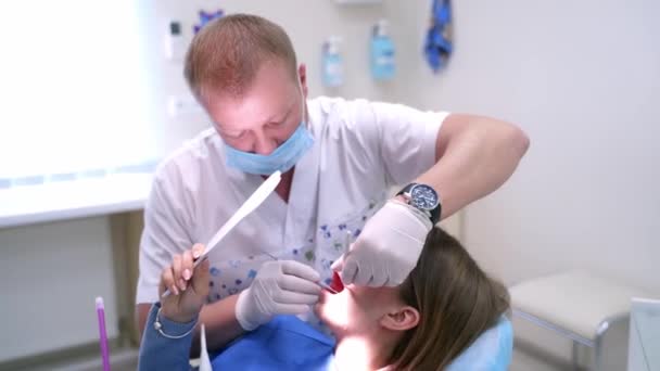 牙科诊所的女病人 牙科医生在牙科诊所检查戴镜牙的病人 — 图库视频影像