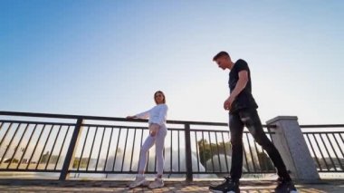 Açık havada dans eden çift. Gündelik giyinen gençler nehir kıyısında dans ediyorlar.