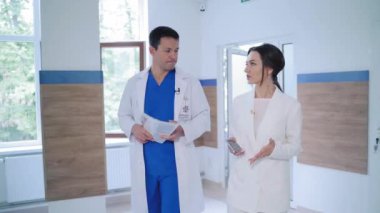 Klinikteki hastanın doktoru. Doktor ve hasta hastanede yürürken bir şey tartışıyorlar.