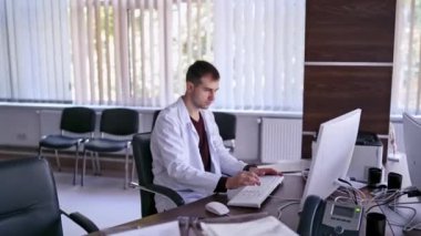 İşyerindeki Doktor usin bilgisayarı. Ofisteki bilgisayarında daktilo eden doktor.