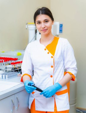 Laboratuvarda elinde elekronik pipeti olan hemşire. Kan ve idrar testi. Virüs enfeksiyonu. Zatürree testi. COVID-19 ve koronavirüs teşhisi. Salgın.