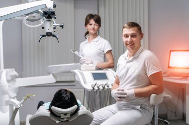 Profesyonel dişçi ve hemşire kadın hastayı ameliyat ediyor. Diş hekimi, diş hekimi, diş bakımı, diş sağlığı, stomatoloji konsepti..