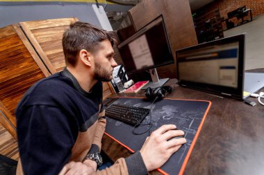 Yazılım geliştirme şirketindeki monitörün yanındaki masaüstü bilgisayarında çalışan erkek programcı. Web sitesi tasarım programlama ve kodlama teknolojileri.