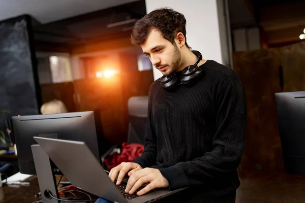 ソフトウェアエンジニアはノートパソコンを手にデスクに座っています 開発会社現代事務所 — ストック写真