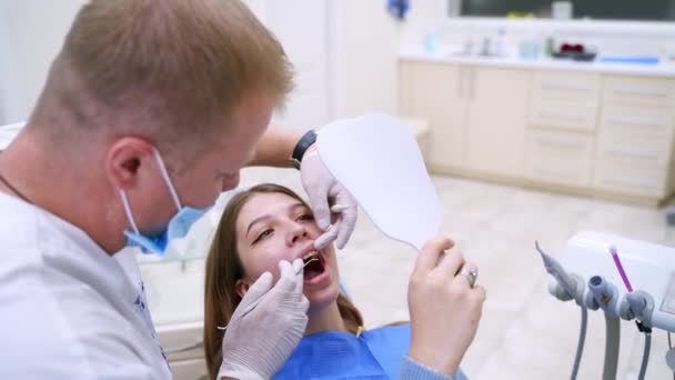 坐在牙科椅子上的病人 到牙医诊所看病的年轻女性病人 — 图库视频影像