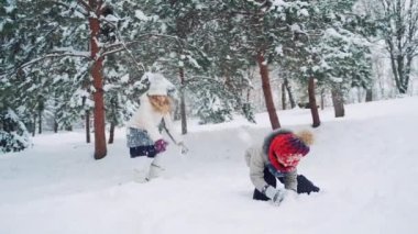 Çocuklar karda dışarıda oynarlar. Mutlu çocuklar eğleniyor, kış yürüyüşünde dışarıda oynuyorlar.