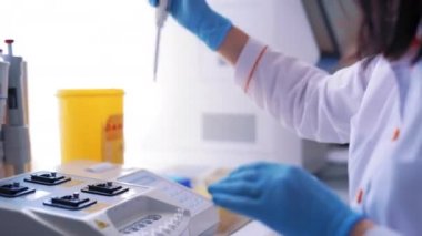 Modern tıbbi laboratuvar ekipmanları. Laboratuvarda deneyler yapan yetişkin kadın bilim adamının yan görünüşü