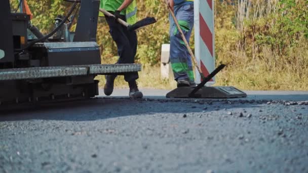 アスファルトの建設でチームワーク 道路建設時のシャベルでアスファルトを作る労働者 — ストック動画