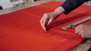 Terzi şablonla çalışıyor. Materyali bir bant ile ölçen terzi görüntüsü