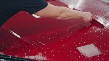 Otomobil servis elemanları araba temizliyor. Araba galerisinde profesyonel temizlik ve araba yıkama.
