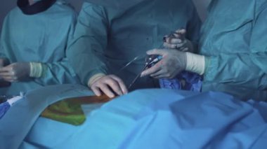 Doktor ameliyat yapıyor. Profesyonel zeki cerrahlar hastanın yanında durur ve hayatını kurtarırken ameliyat yaparlar.