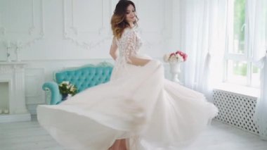 Işık odasında güzel bir gelin. Gelin içeride, beyaz stüdyo içinde tıpkı evdeki gibi güzel elbiseler içinde.