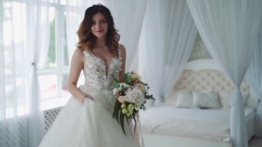 Yatak odasında genç ve güzel bir gelin. Beyaz gelinlik içinde güzel genç gelin.
