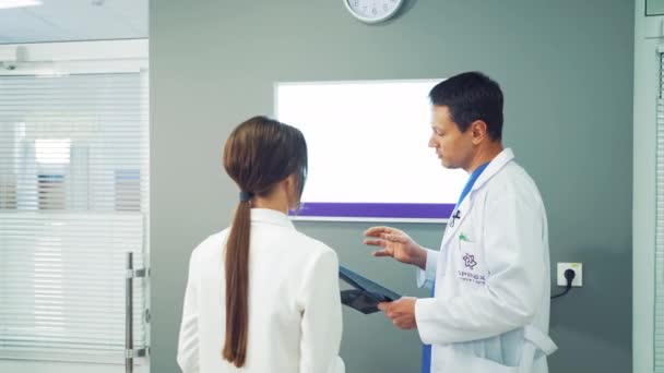 Doctor Mirando Radiografía Rayos Médico Varón Con Enfermera Mirando Atentamente — Vídeos de Stock